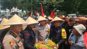 Polisi-melakukan-aksi-potong-tumpeng-memperingati-Hari-Tani-Nasional-ke-65-Rabu-2492025.jpg