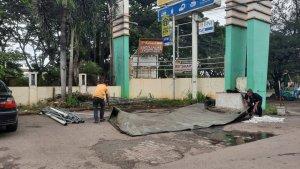 pekerja-merapikan-tenda-yang-roboh-akibat-hujan-disertai-angin-kencang-di-depan-bank-bsi.jpg