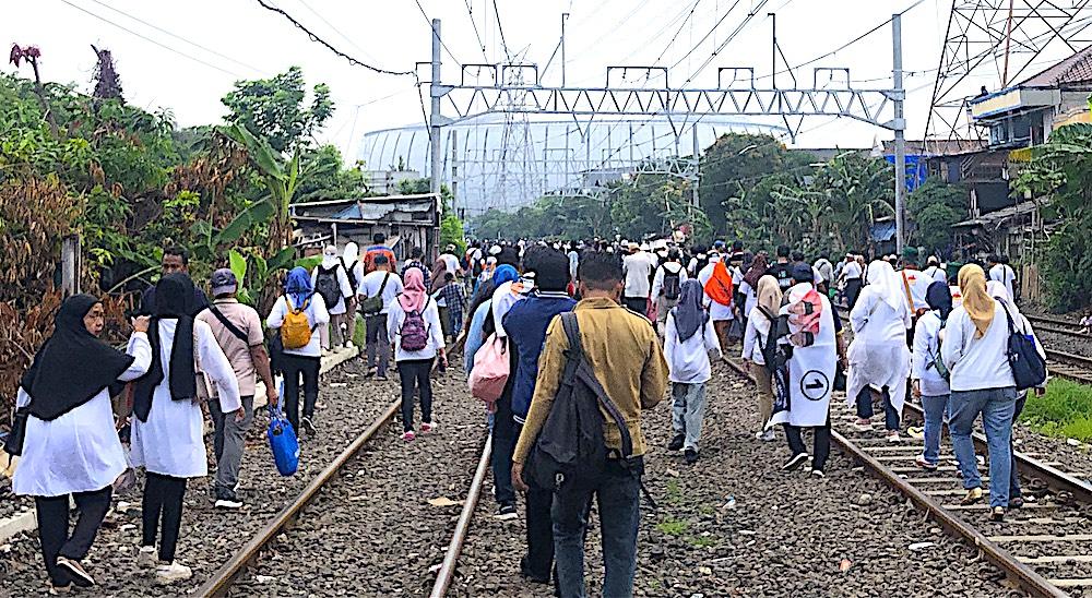 Suasana Pendukung Anies-Cak Imin Melintasi Sepanjang Rel Kereta Imbas Lalu Lintas Menuju JIS Padat