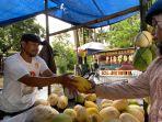 Salah-satu-pedagang-buah-timun-suri-terlihat-santai-sambil-menunggu-pembeli.jpg