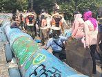 Wakil-Camat-Tanah-Abang-Dwiarti-pegang-sajam-serta-jajaran.jpg