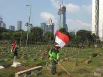 petugas-tpu-karet-bivak-bekerja-sambil-gendong-bendera.jpg