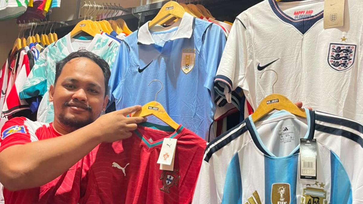 SAMBUT PESTA BOLA - Nofi Setiawan penjual jersey negara yang berlaga di Piala Dunia 2026 sedang memamerkan barang dagangannya di Mojosongo, Solo, Rabu (10/6/2026).