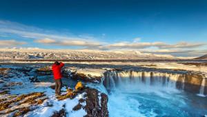 Seorang-Fotografer-mengambil-foto-di-air-terjun-godafoss-di-musim-dingin-islandia.jpg