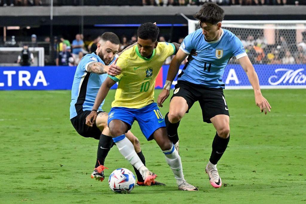 Penyerang-Brasil-Rodrygo-tengah-berebut-bola-dengan-bek-Uruguay.jpg