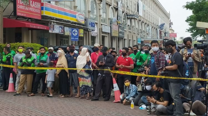 warga-berkerumun-berdiri-di-belakang-garis-polisi-di-lokasi-penyerangan-kelompok-john-kei.jpg