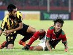 gelandang-timnas-u-16-indonesia-mochammad-supriadi-kanan-dilanggar-pemain-malaysia-pada-l.jpg