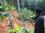 seorang-warga-memerlihatkan-sisa-longsoran-di-lereng-bukit.jpg