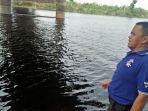 trisno-saat-menunjukkan-air-di-aliran-bengawan-solo-yang-berubah-coklat-kehitaman.jpg